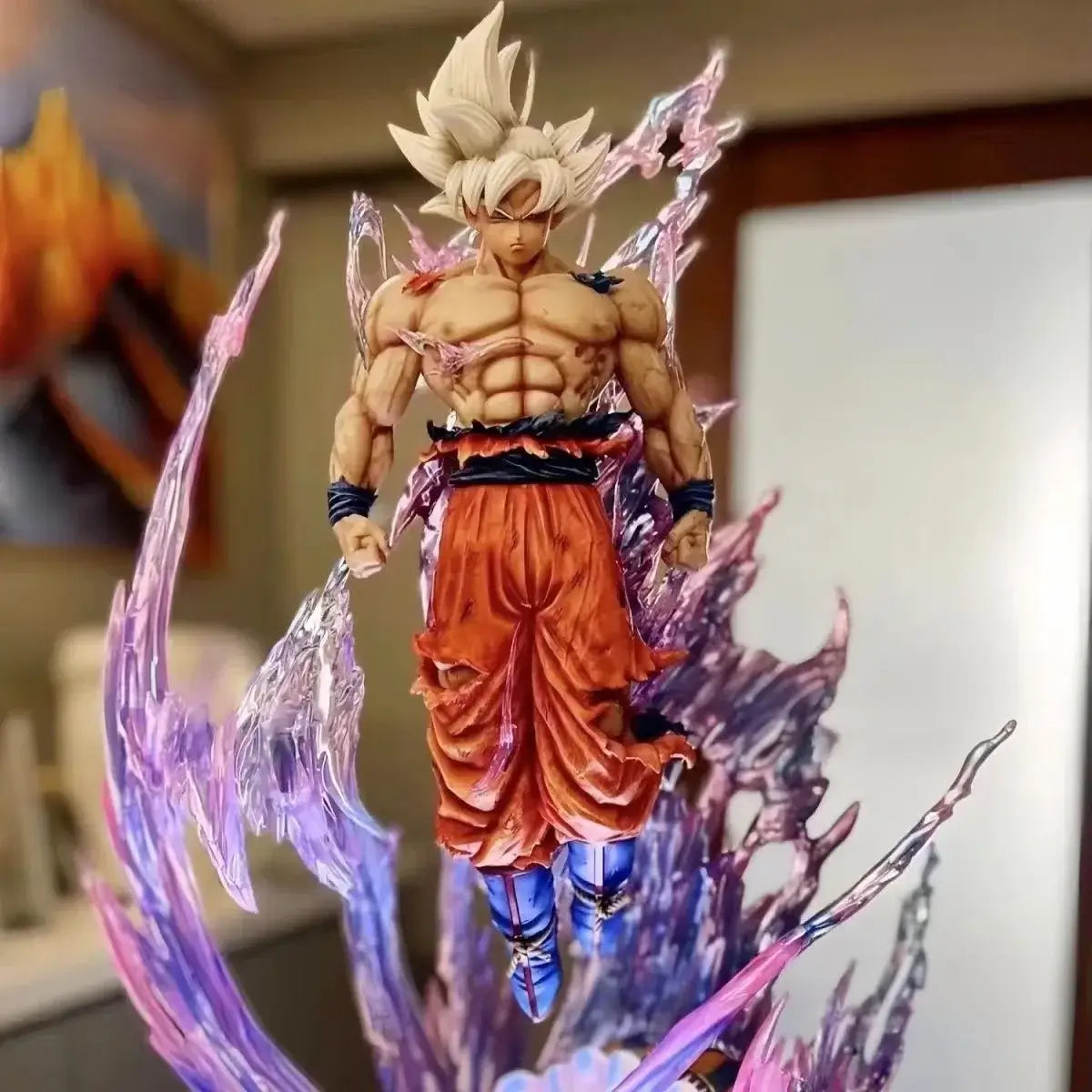 Goku Ultra Instinct figure in dynamic pose with vibrant energy effects, perfect for collectors and fans.